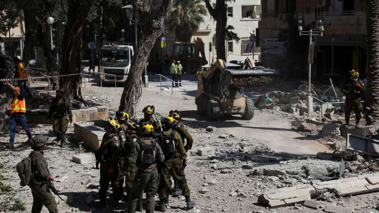 Equipes de resgate se reúnem em um local de impacto após um ataque do Irã em Haifa, Israel, em 22 de junho de 2025.