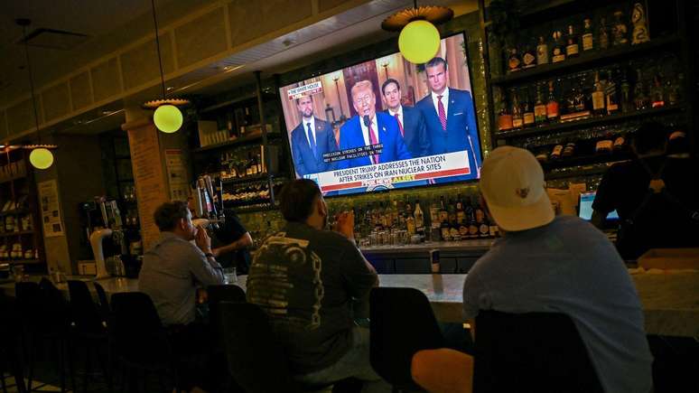 Pessoas veem o pronunciamento de Trump pela TV em Chicago, nos EUA