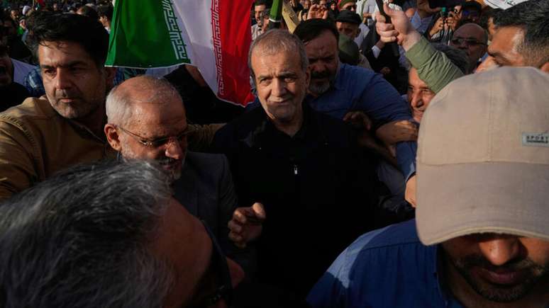 O presidente iraniano Massoud Pezeshkian, ao centro, participa de um protesto após ataques dos EUA a instalações nucleares no Irã. Em Teerã, em 22 de junho de 2025.