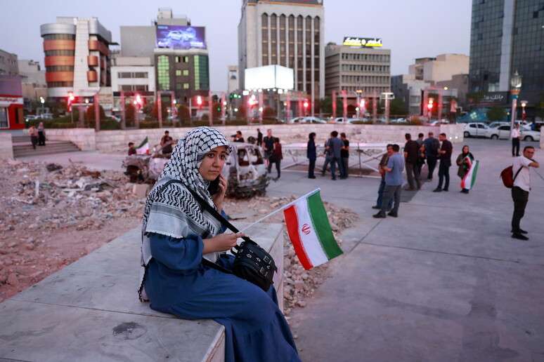 Iraniana demonstra apoio ao país com bandeira nacional