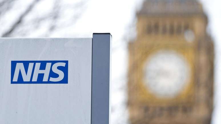 Uma placa do NHS é exibida no Hospital St. Thomas, em frente ao relógio do Big Ben e à Torre Elizabeth, em 13 de janeiro de 2017, em Londres (imagem de ilustração).
