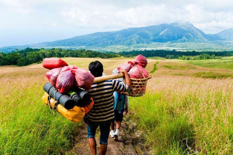 Um carregador leva os pertences de montanhistas no Monte Rinjani