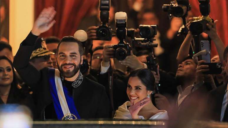 O presidente de El Salvador e a esposa, Gabriela Bukele, cumprimentam seus apoiadores ap&oacute;s ele discursar por ocasi&atilde;o dos seis anos do seu mandato