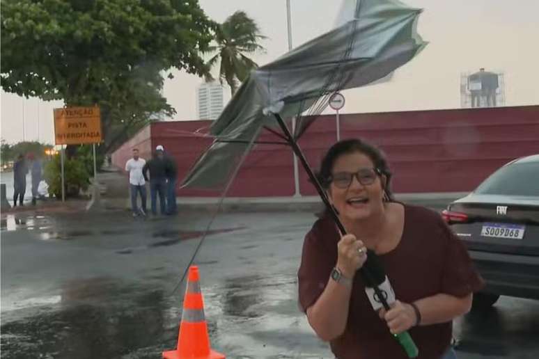 Guarda-chuva de jornalista quebra com o vento em PE e repórter cai na risada