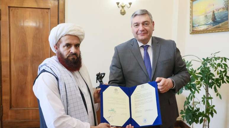 Nesta imagem divulgada pelo Ministério das Relações Exteriores da Rússia em 3 de julho de 2025, o novo enviado dos talibãs em Moscou, Gul Hassan, entrega cópias de suas credenciais ao vice-ministro das Relações Exteriores, Andrei Rudenko.