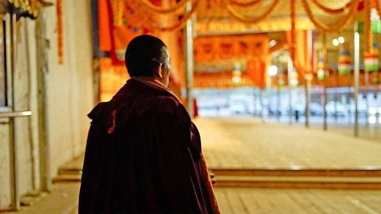 Um monge tibetano durante as orações matinais no mosteiro de Kirti