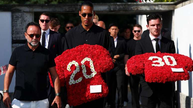 Virgil van Dijk e Andrew Robertson seguram coroas de flores com os números 20 e 30.