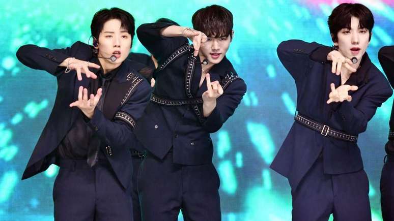 Bain (ao centro) fez sua estreia em 2021 como parte de uma boy band de seis membros, a Just B