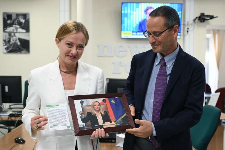 Meloni foi presenteada durante a visita pelo diretor da ANSA, Luigi Contu