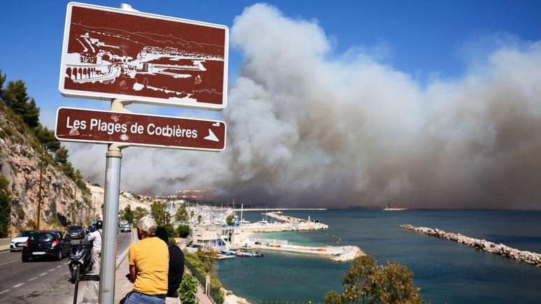 Fumaça cobre os céus de Marselha e moradores observam próximo à praia de Corbieres, em 8 de julho de 2025.