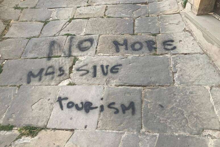 Pichação contra o turismo de massa na cidade italiana de Cortona, na Toscana