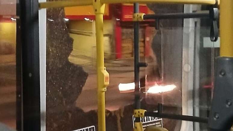 Vândalos usam pedra para quebrar janelas de ônibus.