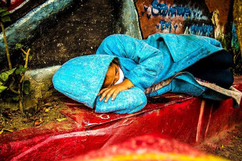 Projeto de transformar cobertores em sobretudos começou durante a pandemia. Roupa vira travesseiro e bag.