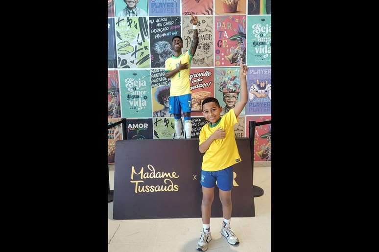 Enzo ao lado da est&aacute;tua de Vini Jr, em S&atilde;o Gon&ccedil;alo &ndash;