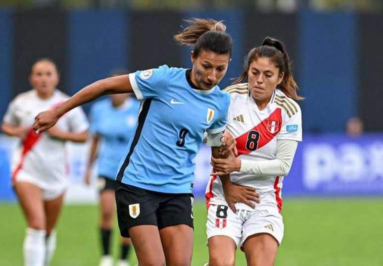 A uruguaia Pamela González, à esquerda, recebe a marcação cerrada, e até agarrão, da peruana  Cisneros. Mas no fim, deu Celeste. Divulgação/Conmebol