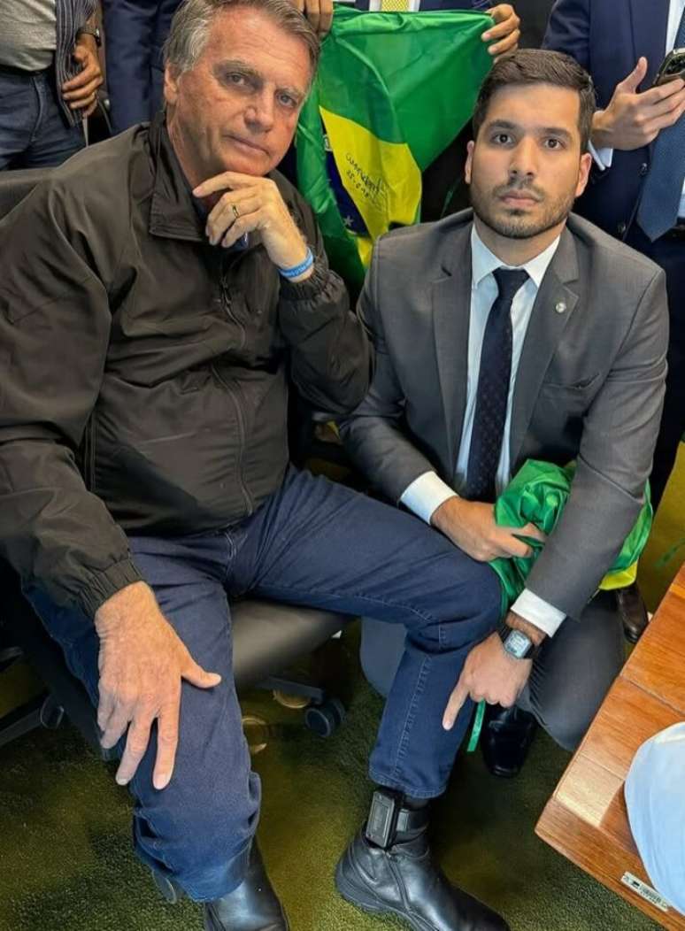 முன்னாள் ஜனாதிபதி ஜெய்ர் போல்சனாரோ துணை ஆண்ட்ரே பெர்னாண்டஸுக்கு அடுத்ததாக மின்னணு கணுக்கால் வளையலைக் காட்டுகிறார்