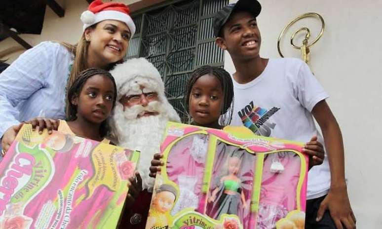 Preta Gil distribuindo presentes no Complexo do Alemão. Cantora também distribuía cesta básica e mobilizava outros artistas.