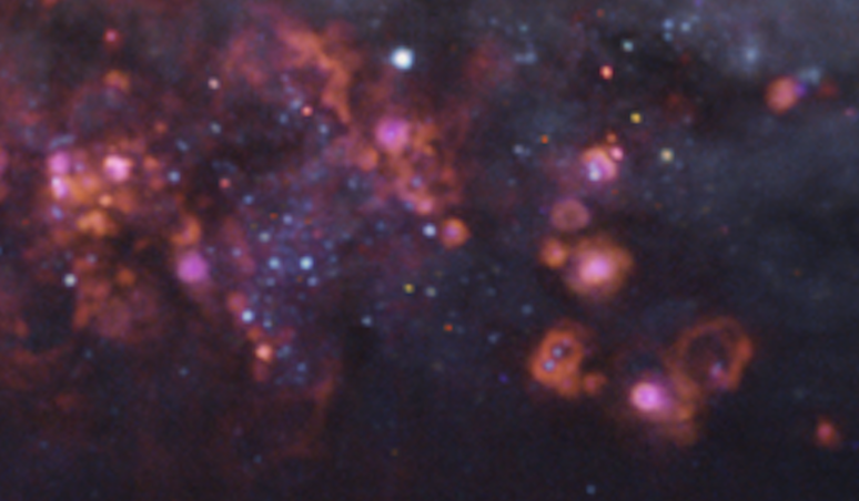 Nuvens de g&aacute;s pontuadas por pontos brilhantes que representam estrelas.