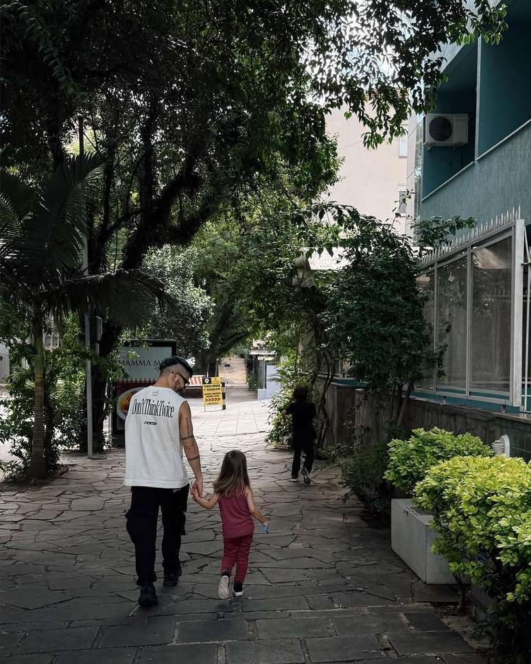 Junior Lima e sua filha, Lara, andando por uma rua