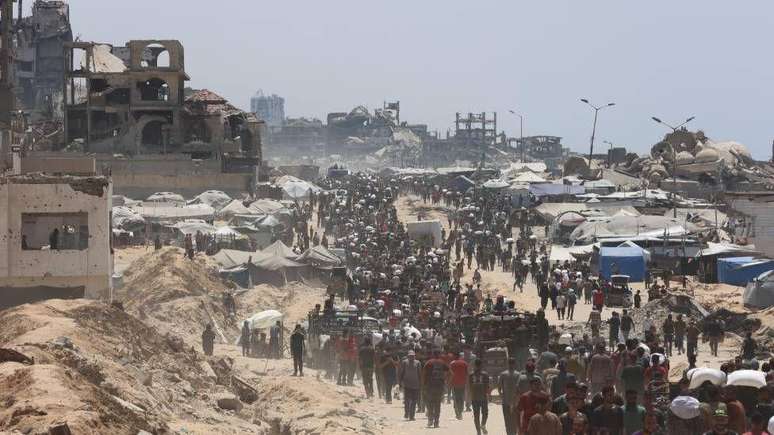 Palestinos famintos caminham at&eacute; a regi&atilde;o de Zakim, no norte de Gaza, em busca de alimentos