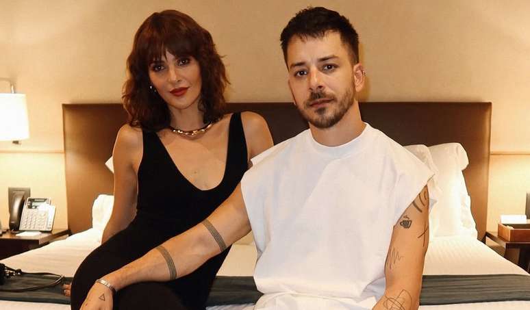 Monica Benini e Junior Lima posam juntos em um quarto de hotel