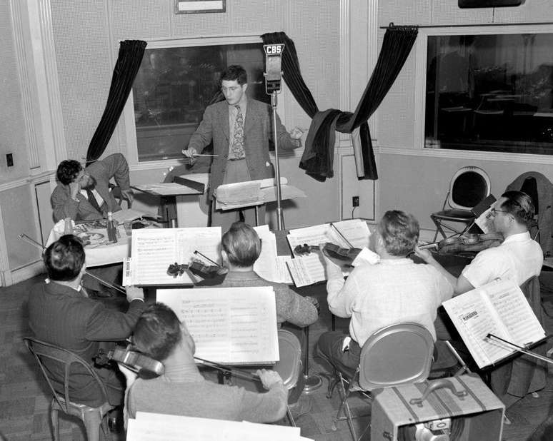 Na CBS, Herrmann (no centro) trabalhou com Orson Welles (sentado ao lado direito de Herrmann) e conquistou sua confian&ccedil;a ao fazer adapta&ccedil;&otilde;es para o r&aacute;dio