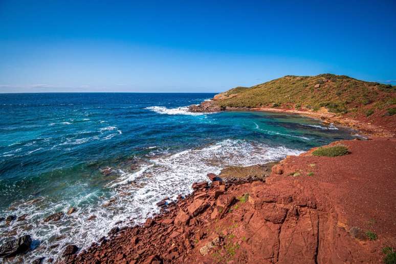 A Praia de Cavalleria se destaca pela areia avermelhada 