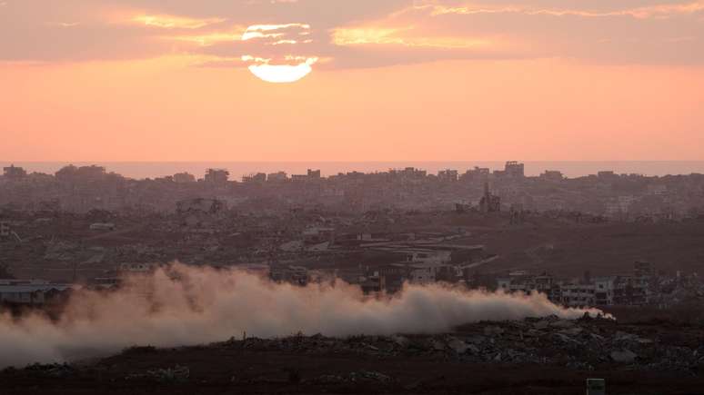 Fumaça se ergue da Faixa de Gaza com o pôr do sol, visto do lado israelense da fronteira em 30 de julho