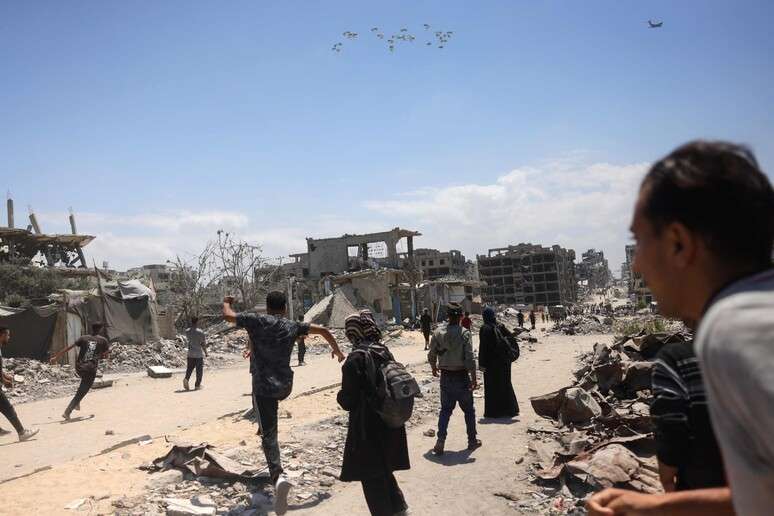 Palestinos correm em direção a avião com ajuda humanitária em Gaza