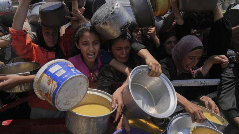 Civis palestinos durante distribuição de comida na Cidade de Gaza, em 26 de julho de 2025.
