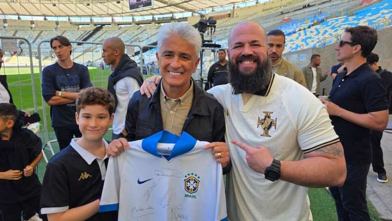 Bebeto mostrando a camisa da seleção autografada