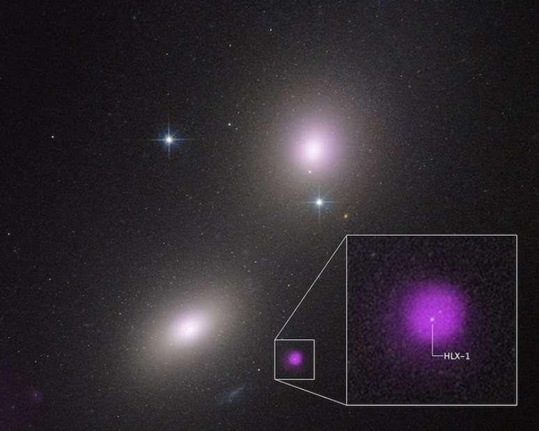 Imagem captada pelo telescópio Espacial Hubble das galáxias NGC 6099 (embaixo à esquerda) e NGC 6098 (em cima à direita). A mancha roxa representa a emissão de raios X, gerado pela destruição de um estrela por um buraco negro de massa intermediária.