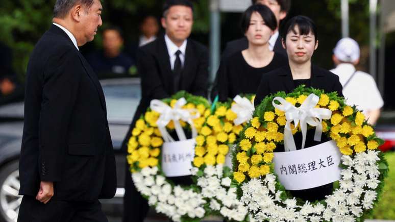 O primeiro-ministro japonês Shigeru Ishiba caminha entre coroas de flores durante o evento que marca o 80º aniversário do bombardeio atômico em Hiroshima, no oeste do Japão, em 6 de agosto de 2025.