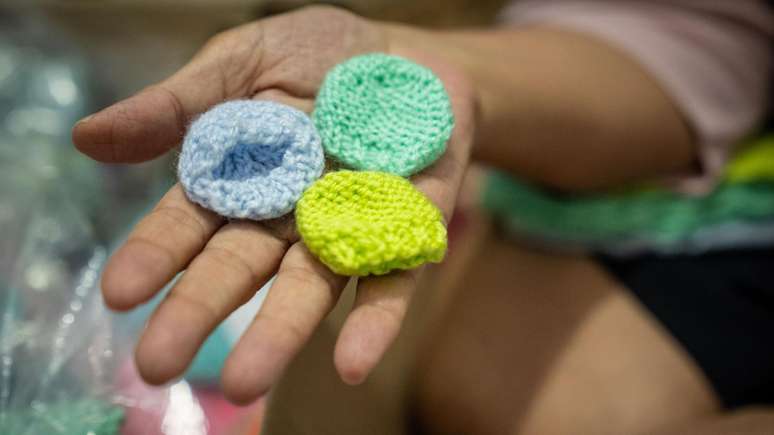 A m&eacute;dica exibe gorros min&uacute;sculos, para beb&ecirc;s que nasceram muito prematuramente e n&atilde;o sobreviveram