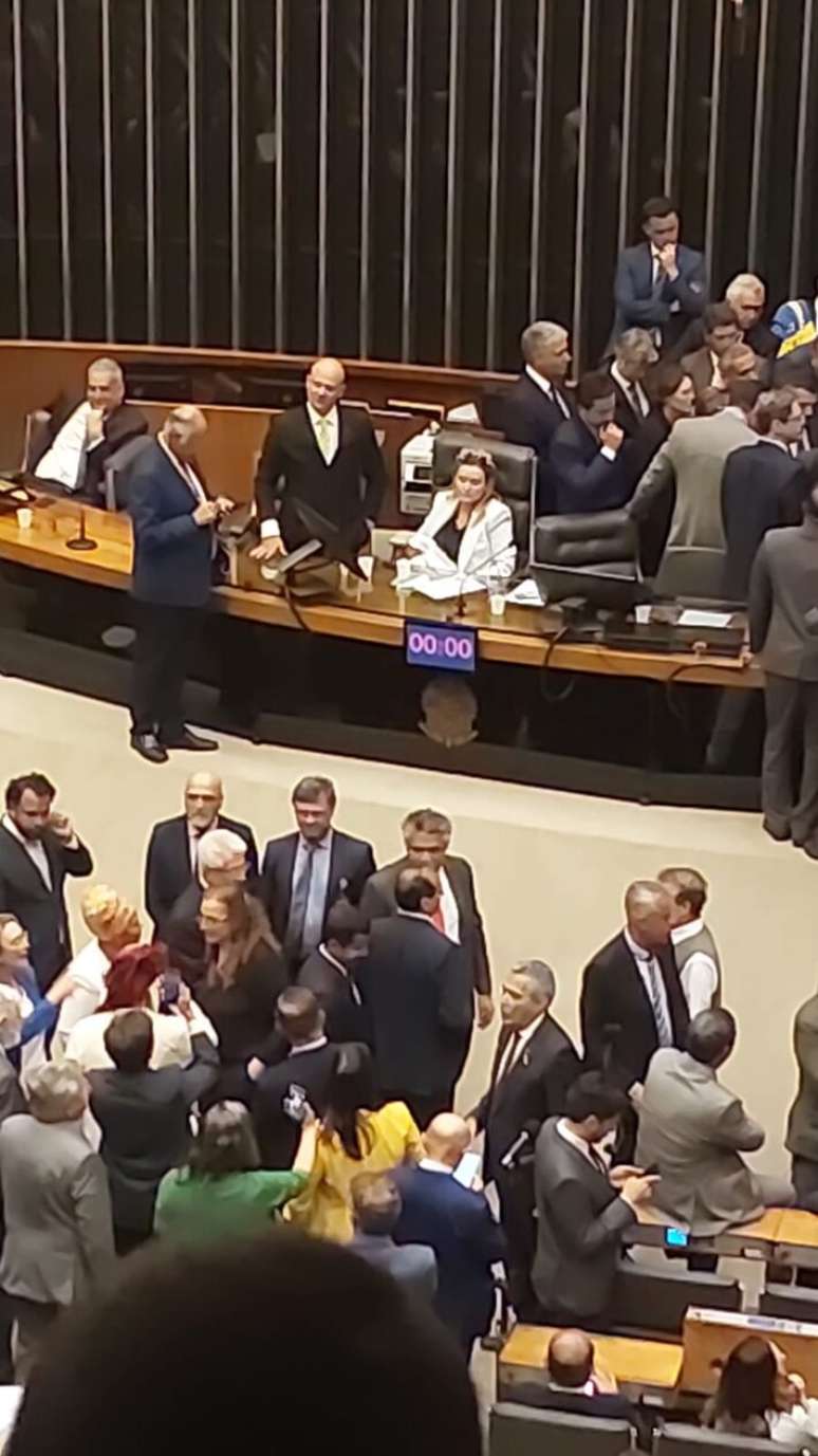 A deputada J&uacute;lia Zanatta aparece sentada na cadeira de Hugo Motta, presidente da C&acirc;mara, com a filha no colo