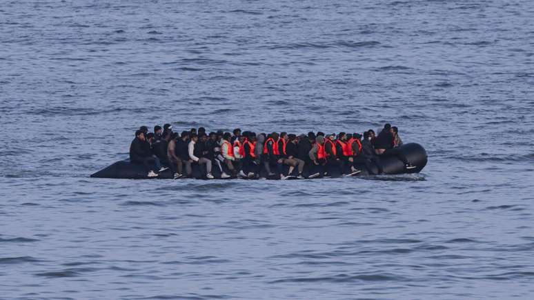Migrantes navegam a bordo de um barco de contrabandistas em uma tentativa de atravessar o Canal da Mancha na praia de Neufchatel-Hardelot, norte da França, em 18 de junho de 2025.
