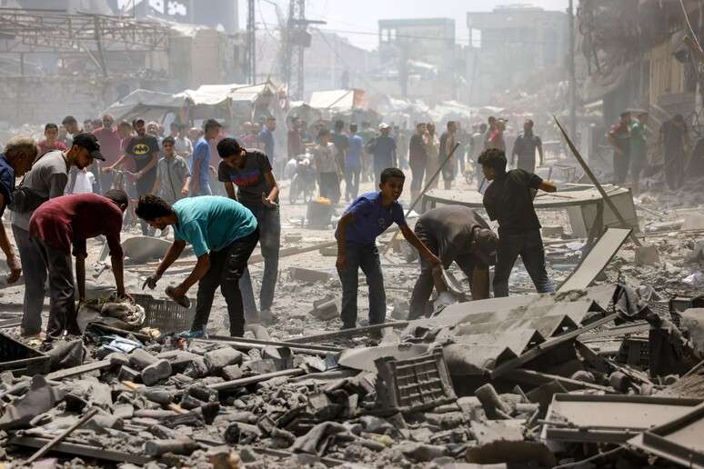 Palestinos vasculham entulhos ap&oacute;s bombardeio israelense na Cidade de Gaza, em 8 de agosto