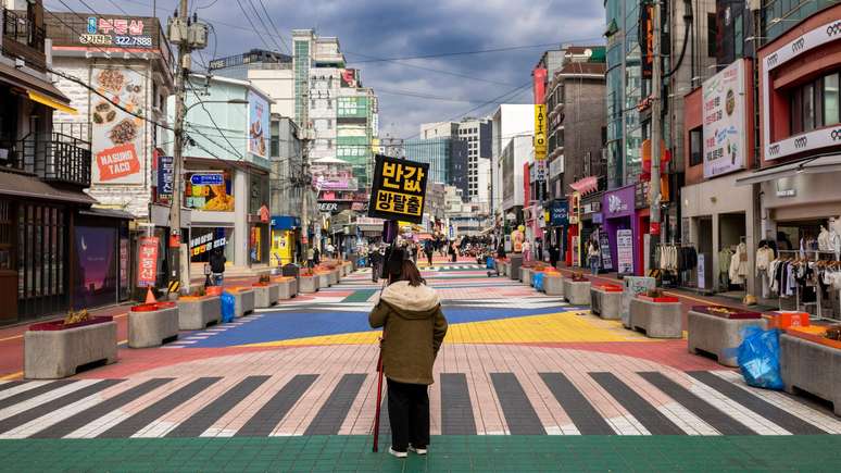 A placa diz 'sala de escape, metade do preço' numa popular rua de pedestres em Seul. A cidade tem a missão de evitar a crescente solidão entre seus habitantes