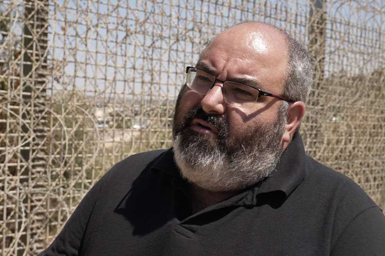 Yehuda Shaul em frente a uma cerca alta