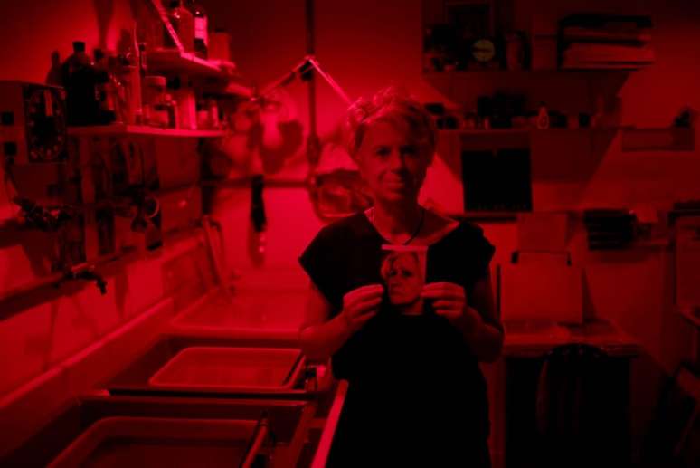 Rosangela Andrade segura foto revelada de sua m&atilde;e no laborat&oacute;rio Im&aacute;gicas.