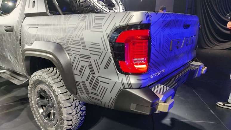 Traseira tem ca&ccedil;amba alta, lanternas verticais e o nome RAM estampado na tampa