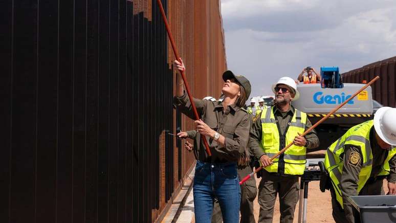 A secretária de Segurança Interna dos EUA, Kristi Noem, falou com jornalista após pintar muro na fronteira