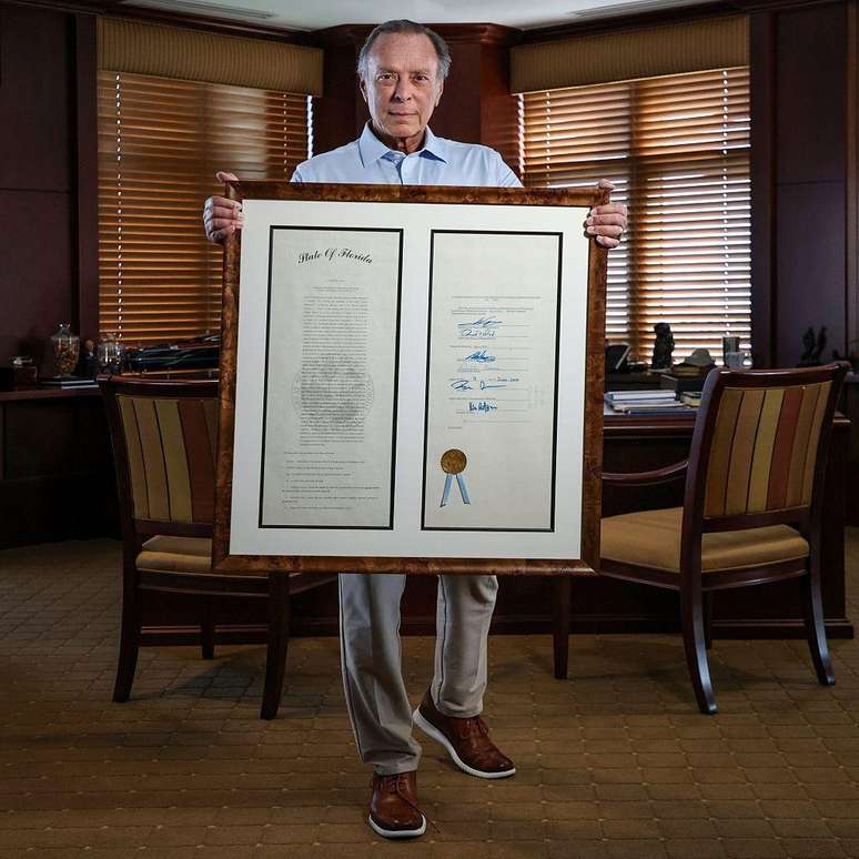 O filantropo Miguel 'Mike' B. Fern&aacute;ndez mostra a lei de matr&iacute;cula estadual para imigrantes sem documentos que ele ajudou a aprovar, mas que, agora, ficou sem efeito