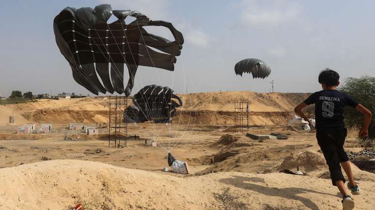 Garoto palestino corre em busca de mantimentos atirados por aeronave indonésia em Gaza