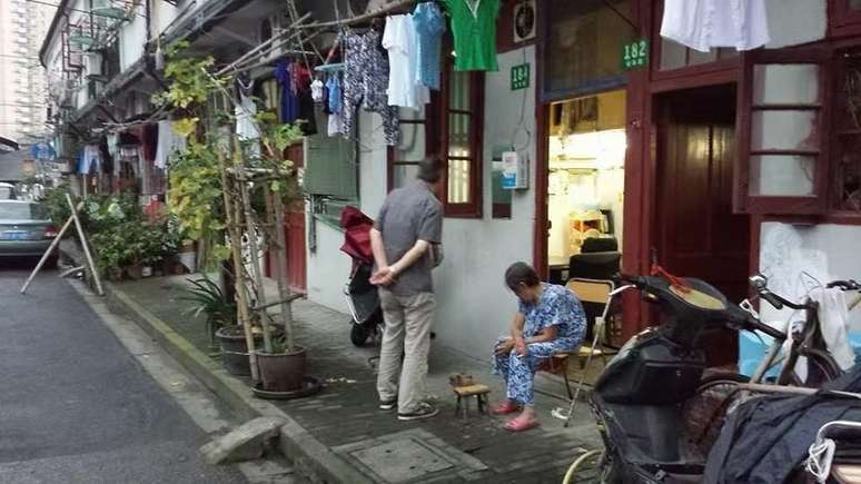 Subúrbio de Shanghai, com 25 milhões de habitantes. A presença de idosos nas calçadas e praças é notável.