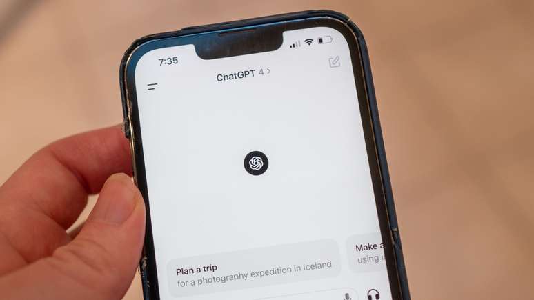 A mão de uma pessoa segura um iPhone com o aplicativo ChatGPT da OpenAI aberto, exibindo o GPT-4
