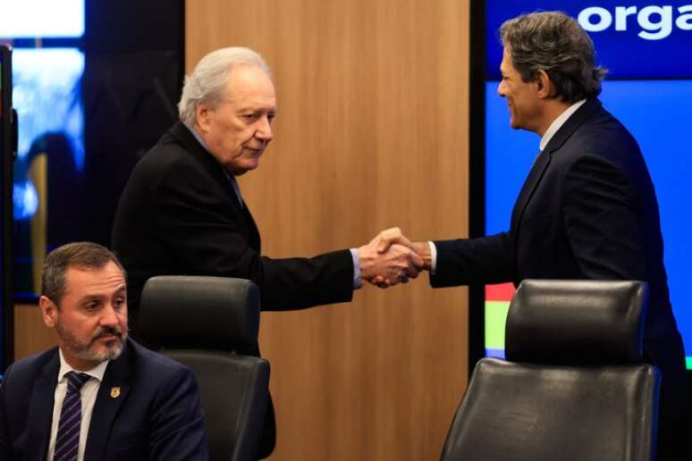 Os ministros Ricardo Lewandowski (Justiça) e Fernando Haddad (Fazenda) se cumprimentam durante coletiva sobre Operações contra o crime organizado no setor de combustíveis