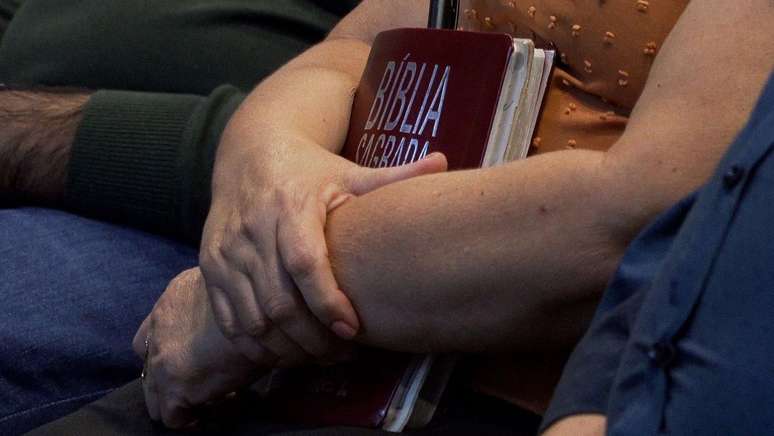 Pessoa segurando B&iacute;blia no colo