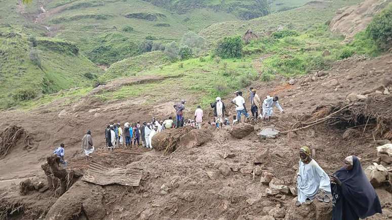 Imagem divulgada pelo grupo rebelde Movimento de Libertação do Sudão em 1º de setembro de 2025, mostra pessoas inspecionando destroços após um deslizamento de terra ter devastado a vila de Tarasin, na região de Jebel Marra, no Sudão.