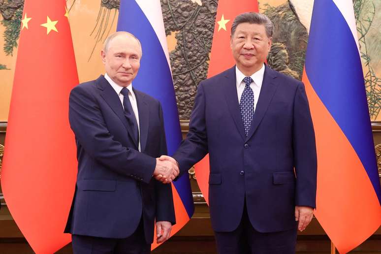 Presidentes da Rússia, Vladimir Putin, e da China, Xi Jinping, cumprimentam-se em Pequim